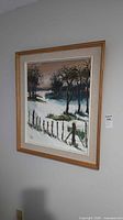 Full view of framed winter landscape painting on wall
