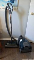 Canister vacuum connected to hose, wand, power nozzle