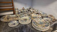 Full lot overview showing stacked plates, bowls, platters, covered pieces and accessory items