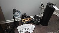 Group view showing camera on box, manuals, clock, heater, lamp and case