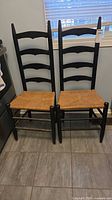 Two black ladderback chairs side by side