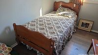 Twin bed made up with floral cover showing headboard and partial footboard