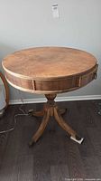 full view of round pedestal table showing top surface, pedestal, legs