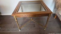 Full view of square wood and metal end table with glass top