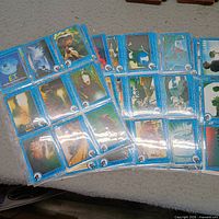 Spread view of multiple blue-border E.T. trading cards in plastic sleeves