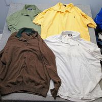 Top view of all four garments laid out: green polo, yellow polo, brown quarter-zip, white polo