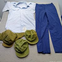 Overall view of shirt, trousers, three caps