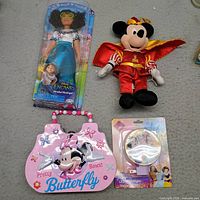 Group shot showing Encanto doll, Mickey plush, Minnie lunchbox, Princess night light