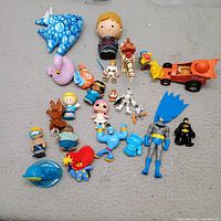 Group shot of entire lot displayed on grey surface showing all figures and plush