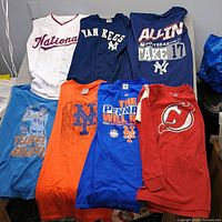 All seven shirts and jerseys laid out on table