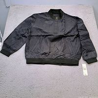 Full view of Nicklaus black jacket laid flat