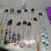 All ten jewellery pieces laid out showing necklaces and earring cards