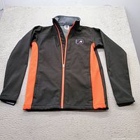 Front view of black and orange Flyers jacket laid flat, full visibility of logo and zipper