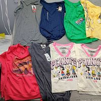 Group shot of all eight shirts laid out showing colors, graphics and tags