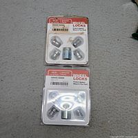 Front view of both sealed Kia wheel lock sets showing contents and packaging