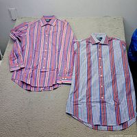 Both Ralph Lauren striped dress shirts laid flat showing front side and patterns