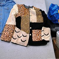 Front view of both jackets showing denim piece and button-front patchwork jacket