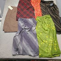 Six plus size skirts laid out showing patterns and tags