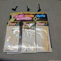 Front view of three Zupa Jewel Tattooz Glow packs attached to cardboard header