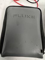 Grey Fluke-branded carry case showing exterior and tear
