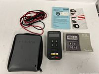 Fluke 12 multimeter with case, leads and manuals displayed