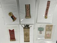 Group shot of all six ribbon badges in sleeves