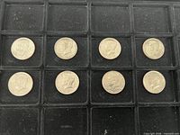 Tray with eight Kennedy half dollars arranged in two rows of four