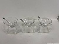 Three complete glass cocktail sets lined up