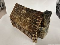 Side view of McCoy log cabin cookie jar showing chimney and textured walls