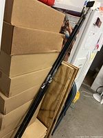 Pair of black adjustable cargo bars leaning against boxes