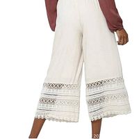 Full view of cream culotte pants showing wide legs and lace trim