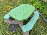 Full view of Step2 green tabletop picnic table with brown faux stone base
