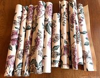 All wallpaper rolls grouped on table showing floral pattern