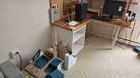 Overall view of desk area showing monitor, router, shredder, desk, shelving and cables