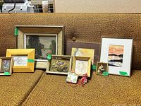 Front view of all eight framed pieces arranged on couch