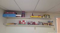 Shelf with barn, fire truck, rescue boat, dollhouse, blocks tube, board game boxes