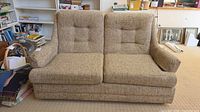 Front view of beige tweed loveseat showing cushions and tufted back