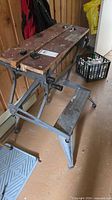 Overall view of folding workbench showing wood top, steel frame and step shelf