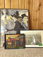 Three framed artworks grouped together against wall