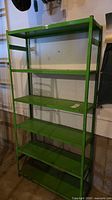 Full frontal view of green metal shelving unit with six shelves