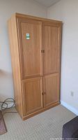 front view of closed light oak armoire