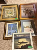 Group shot of five framed artworks on carpet