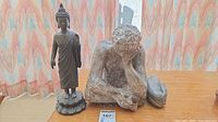 Bronze Buddha, resin thinker figure, broken limb piece on table