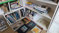 Wide view of two bookcases and oversize books on floor