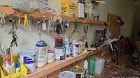 Overview of keys, paint cans, hand tools on shelf