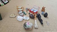Overview of all porcelain, ceramic, wooden and other miniature items on carpet