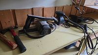 Power tools on shelf: WEN planer, palm sander, hammer, cords visible