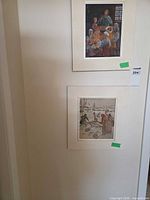 Both framed prints hung on wall for scale and context
