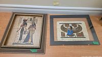 Both framed papyrus prints side by side on floor