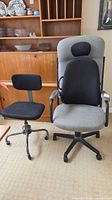 High-back gray/black ergonomic office chair next to smaller black task chair